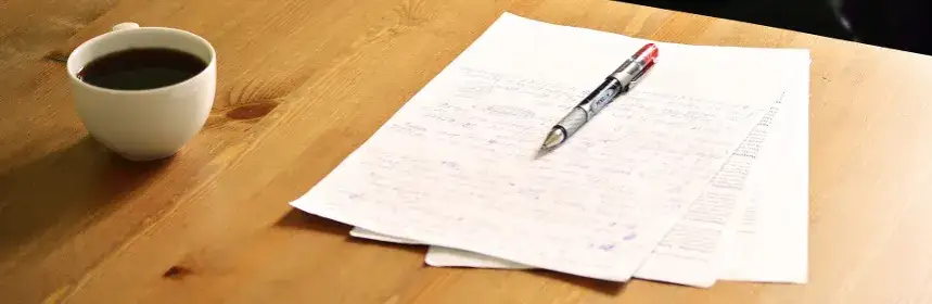 Zesp&oacute;ł redakcyjny pracujący nad tekstem, korektor z długopisem