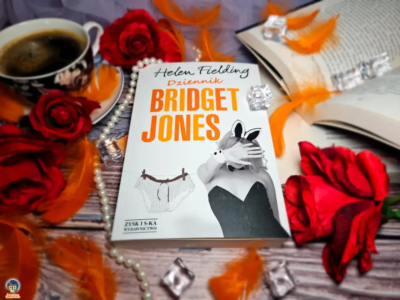 Okładka książki "Dziennik Bridget Jones" na tle róż, piór i kawy.